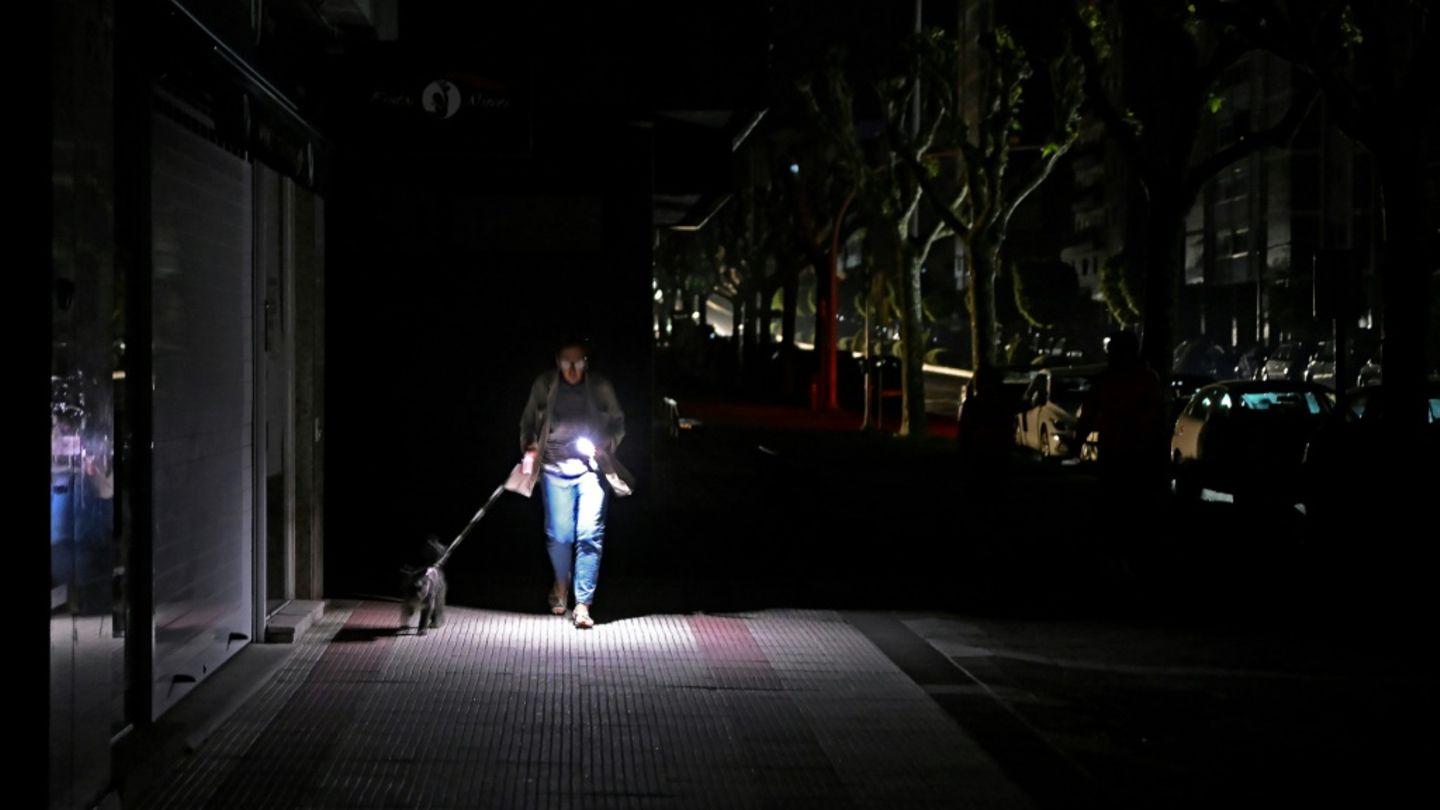 Frau im spanischen Vigo geht im Dunkeln mit Hund Gassi