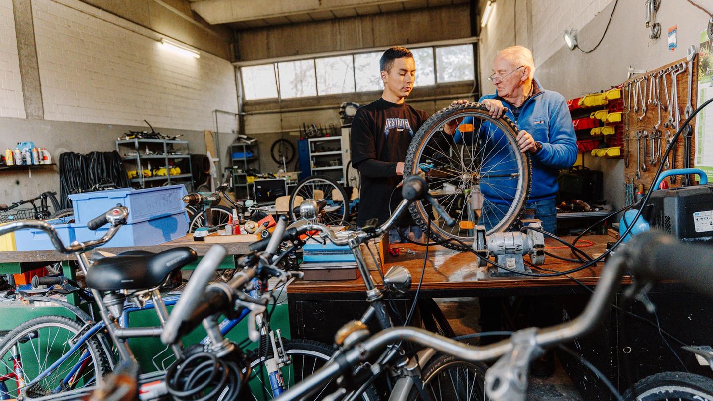 Horst Trzonnek mit einem Geflüchteten in seiner Fahrradwerkstatt