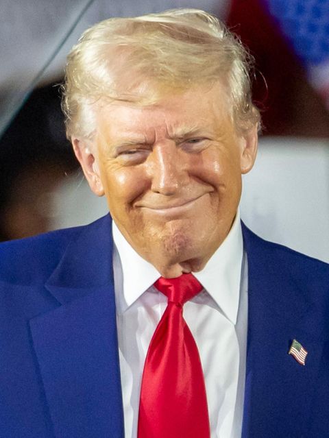 Donald Trump grinst schelmisch auf der Bühne zu einer "Präsidentenfeier"