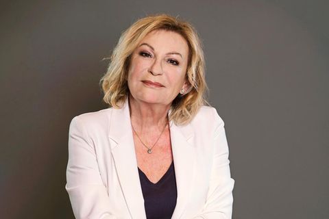 Portrait Sabine Christiansen im Studio, sie trägt einen weißen Blazer