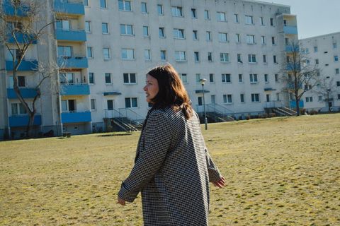 Susanna Stein läuft über einen Rasen vor einem Hochhaus