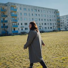 Susanna Stein läuft über einen Rasen vor einem Hochhaus
