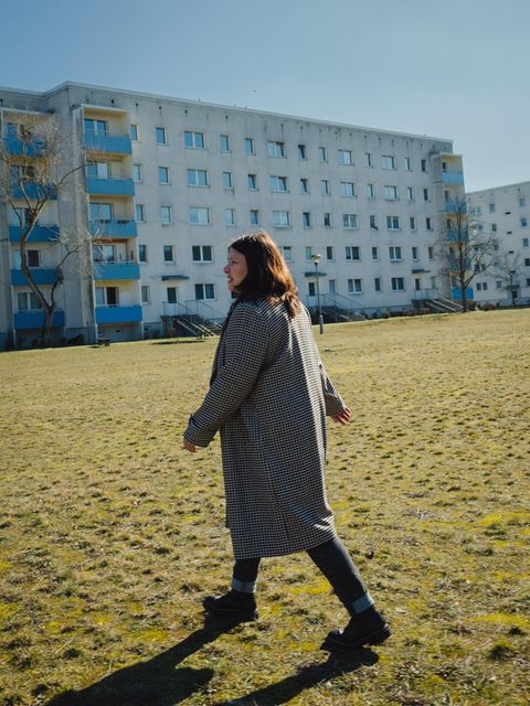 Susanna Stein läuft über einen Rasen vor einem Hochhaus