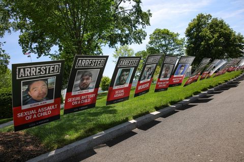 Plakate unterschiedlicher Verhafteter sind an einem US-Straßenrand aufgestellt um die Migranten anzuprangern