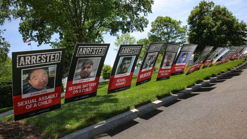 "Operation Springflut": Handy-Videos zeigen Massenfestnahme in den US-Nachtclub Plakate unterschiedlicher Verhafteter sind an einem US-Straßenrand aufgestellt um die Migranten anzuprangern