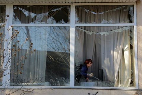 Frau in Odessa entfernt Glassplitter nach russischem Angriff, 22. April