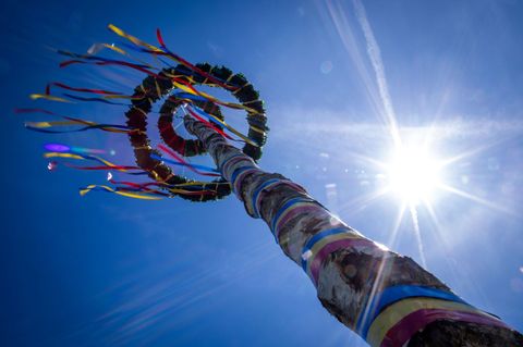 Ein Maibaum von unten zeichnet sich gegen strahlend blauen Himmel ab