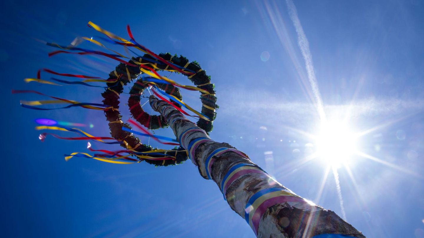 Ein Maibaum von unten zeichnet sich gegen strahlend blauen Himmel ab