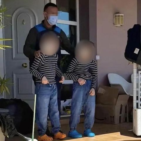 Zwei der drei vernachlässigten Kinder werden von einem Polizisten aus dem "Horrorhaus" geführt