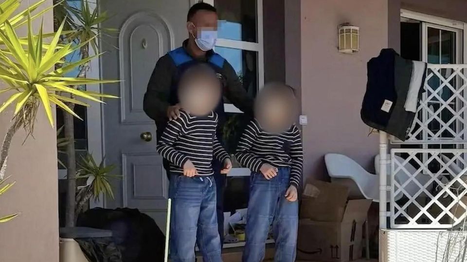 "Keiner hat was geahnt": Deutsche Kinder nach vier Jahren aus Horrorhaus befreit Zwei der drei vernachlässigten Kinder werden von einem Polizisten aus dem "Horrorhaus" geführt