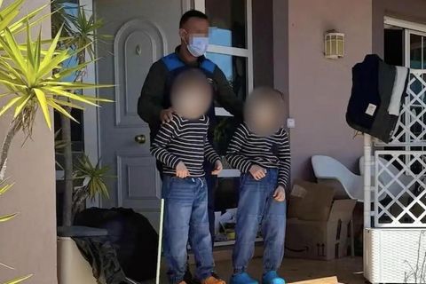 Zwei der drei vernachlässigten Kinder werden von einem Polizisten aus dem "Horrorhaus" geführt