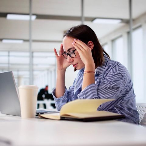 Eine Frau sitzt im Büro vor einem Notebook