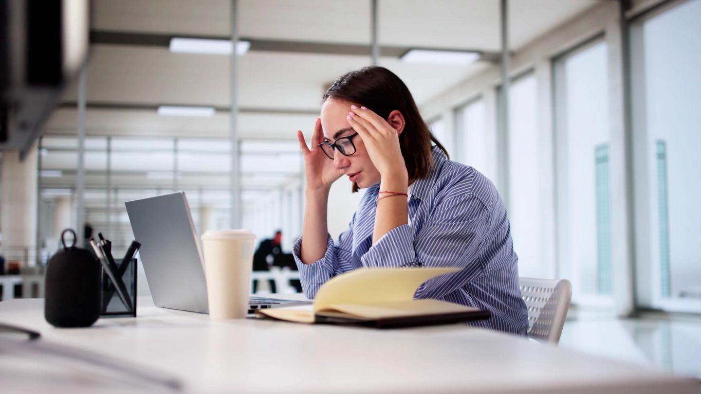 Eine Frau sitzt im Büro vor einem Notebook Eine Frau sitzt im Büro vor einem Notebook