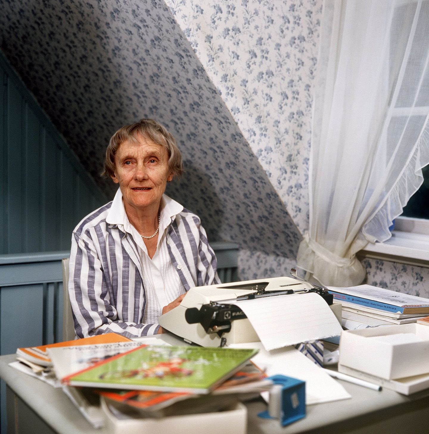 Astrid Lindgren am Tisch mit ihrer Schreibmaschine