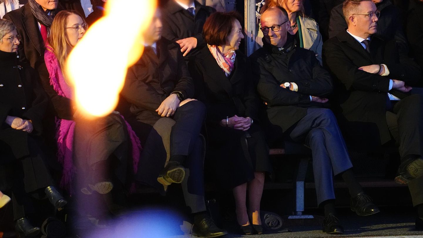 Selbstverständlich ist er zu Gast: Scholz' designierter Nachfolger Friedrich Merz (2.v.r.) sitzt neben seiner Frau Charlotte. Halb verdeckt durch die Fackel ist SPD-Chef Lars Klingbeil zu sehen, links daneben die beiden Fraktionsvorsitzenden der Grünen im Bundestag, Katharina Dröge und Britta Haßelmann