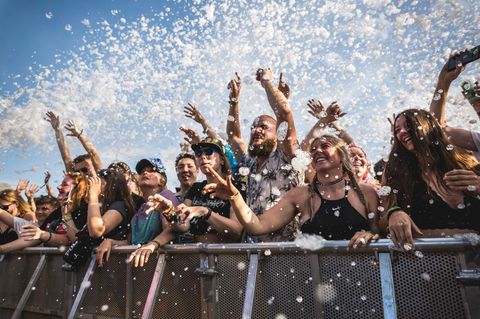 Fans feiern die Musik in der ersten Reihe vor der Bühne auf Eventims Hurricane-Festival – über ihnen schwebt Schaum in der Luft