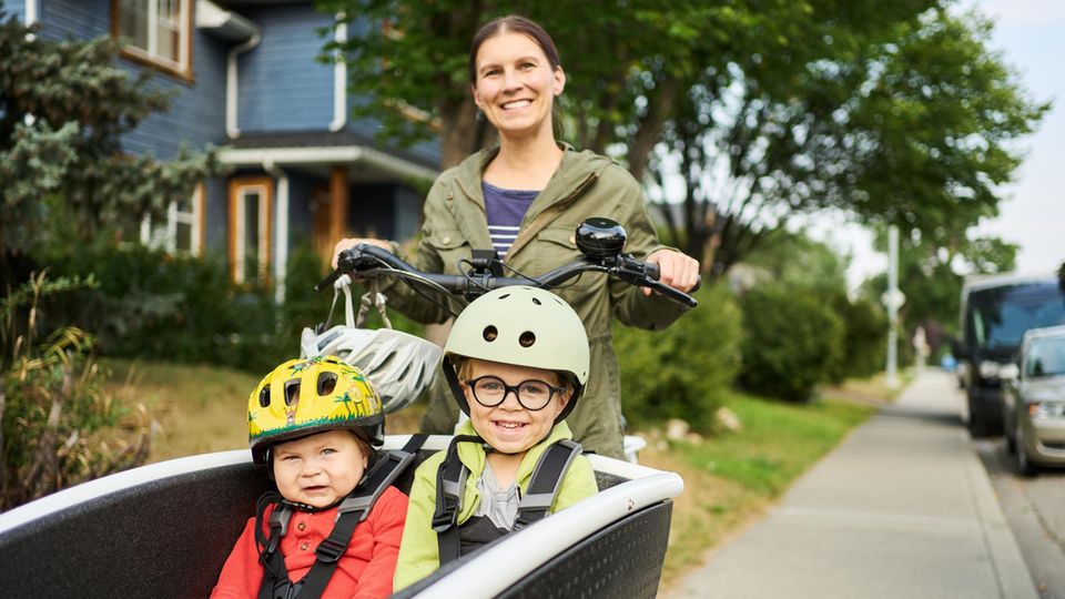 Mutter mit zwei Kindern im E-Bike Mutter mit zwei Kindern im E-Bike