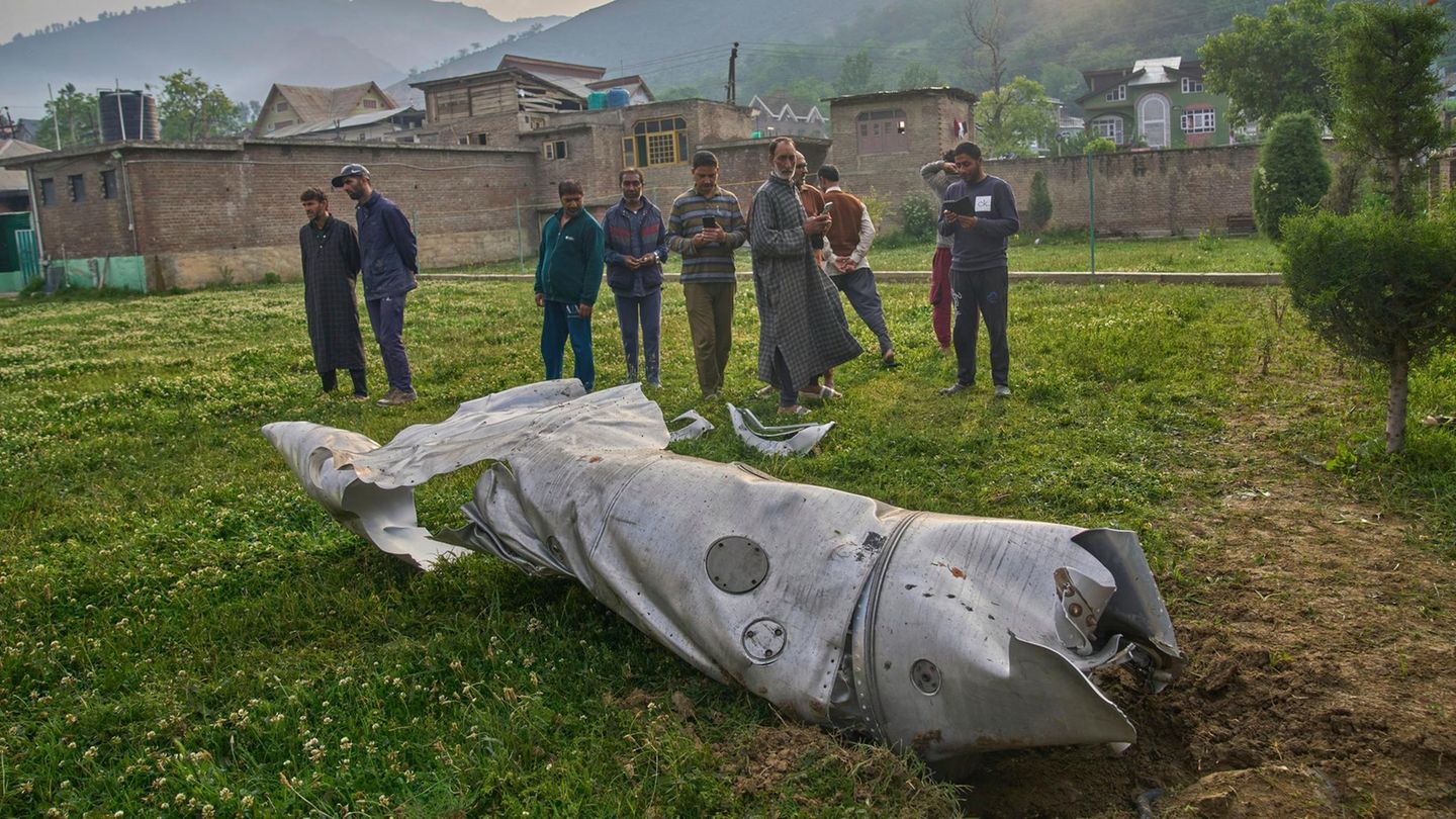 Pampore, Inden. Trümmerteile, die wie Teile eines Flugzeugs aussehen, liegen hinter einem Haus im indisch kontrollierten Kaschmir. In der Nacht greift Indien pakistanische Ziele an. Nach Angaben des pakistanischen Militärs sind dabei 26 Menschen getötet worden. Im indisch kontrollierten Teil des Gebiets sind nach Behördenangaben mindestens acht Menschen durch pakistanischen Beschuss getötet worden. Eskaliert der Konflikt zwischen den beiden Atommächten? Diese Frage stellen sich womöglich auch diese Männer