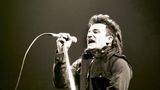 Bono von U2 singt in ein Mikrofon