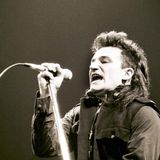 Bono von U2 singt in ein Mikrofon