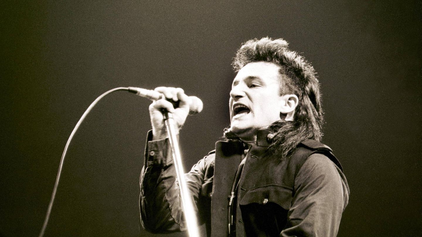 Bono und U2 Bono von U2 singt in ein Mikrofon