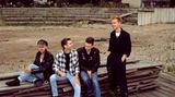 Die Band Depeche Mode 1985 sitzt auf einem Bretterstapel in Berlin