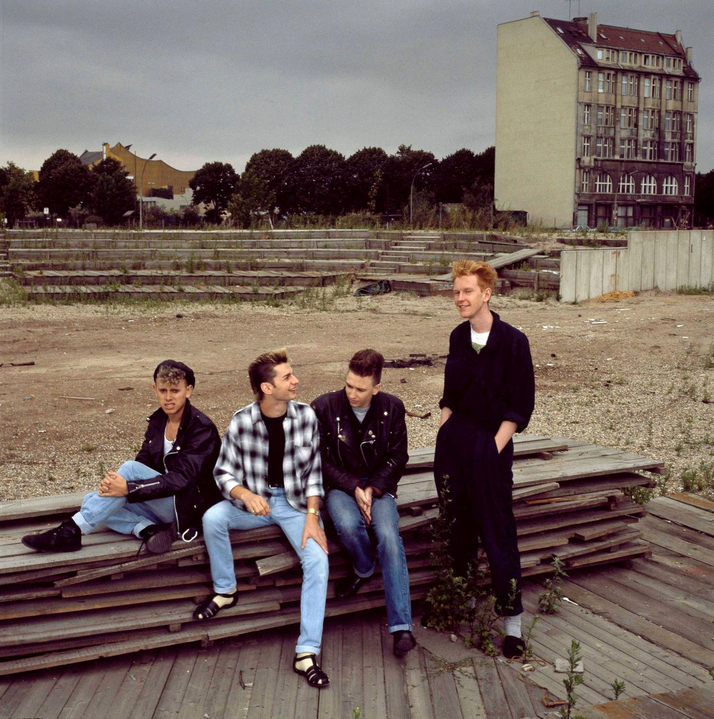 Die Band Depeche Mode 1985 sitzt auf einem Bretterstapel in Berlin