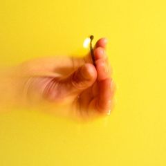 Hand im Wasser mit brennendem Streichholz zwischen den Fingern