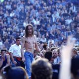 Iggy Pop steht mit freiem Oberkörper vor einem großen Publikum auf der Berliner Waldbühne 1993