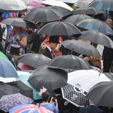 Irgendwo auf diesem Bild ist ein Prinz versteckt: Auch im vergangenen Sommer wurden bei der Gartenparty Schirme benötigt – William (in der Mitte mit Zylinder) nahm es gelassen