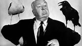 Alfred Hitchcock mit je einer Möwe und einer Krähe auf den Schultern