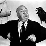 Alfred Hitchcock mit je einer Möwe und einer Krähe auf den Schultern