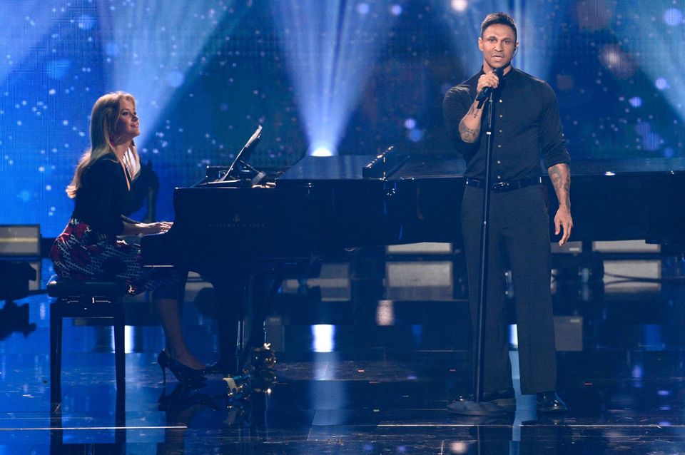 Patrice Aminati sitzt am Klavier und spielt, Daniel Aminati steht davor und singt