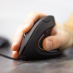 Eine ergonomische Maus liegt in der Hand