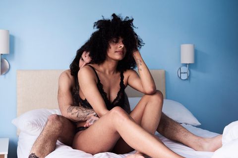 Orgasmus: Junges Paar sitzt eng umschlungen auf dem Bett