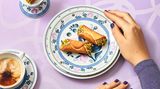 Cannoli  Ein sizilianischer Klassiker mit knuspriger Hülle und cremiger Ricotta-Füllung – ein Stück Italien für Ihre Küche.  Zutaten:250 g Weizenmehl (Type 405) + mehr zum Ausrollen25 g ZuckerSalz25 g Schweineschmalz (zimmerwarm)80 g Marsala oder ein anderer Süßwein2 Eigelb500 g Ricotta25 g Puderzucker25 g dunkle Schokolade1 unbehandelte Orange (Schale)50 g Pistazien (geschält, ungeröstet)14–16 kleine Bambusabschnitte (ca. 12 cm) oder Metallzylinder  Zubereitung:  Für den Teig Mehl, Zucker und eine Prise Salz mit dem Schmalz zu einer krümeligen Masse verarbeiten. Marsala und Eigelb dazugeben und zu einem festen, leicht elastischen Teig kneten. 1 Stunde ruhen lassen.  Für die Füllung den Ricotta in ein Tuch wickeln, ausdrücken und mit Puderzucker glatt rühren. Geraspelte Schokolade und Orangenabrieb untermischen und in einen Spritzbeutel füllen. Die Pistazien hacken.  Den Teig etwa 2 mm dünn ausrollen, mit einem 7,5 cm-Ring ausstechen. Die Scheiben um die Bambusabschnitte oder Zylinder wickeln und die Enden gut andrücken.  Das Fett auf 170 Grad erhitzen und die Cannoli samt Stäben 3–4 Minuten frittieren. Von den Stäben lösen, nochmals 1 Minute frittieren und auf Küchenpapier abtropfen lassen. Nach dem Abkühlen mit Ricotta füllen und die Enden in die Pistazien dippen.  Profi-Tipp: Als Fett am besten Schweineschmalz verwenden.