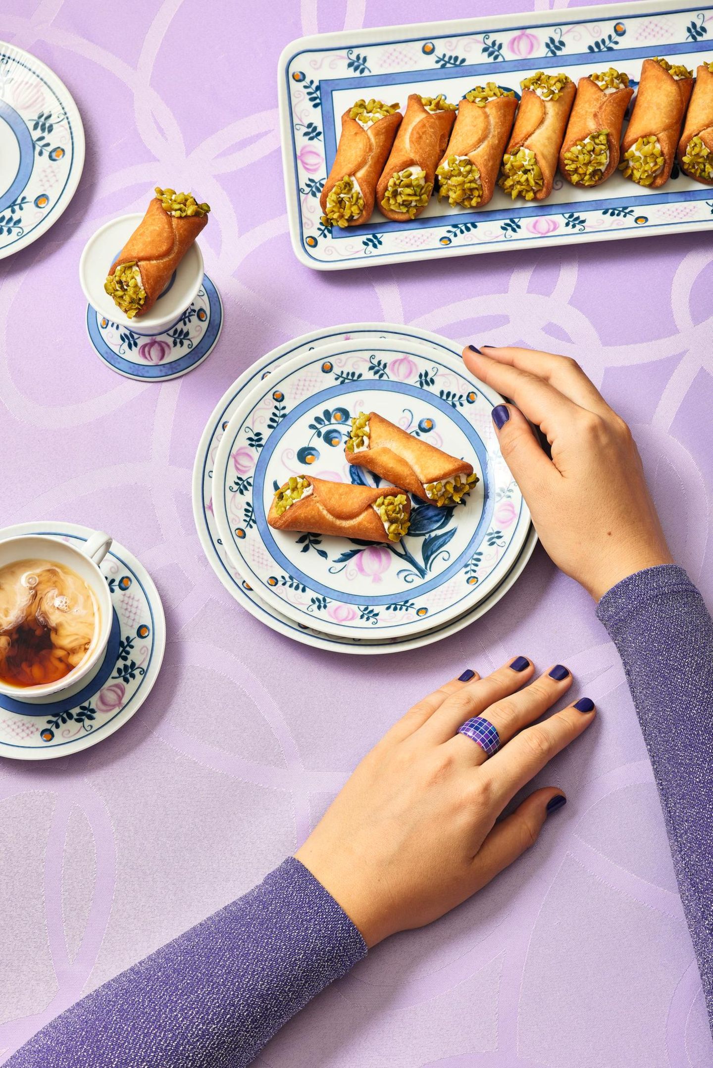 Cannoli  Ein sizilianischer Klassiker mit knuspriger Hülle und cremiger Ricotta-Füllung – ein Stück Italien für Ihre Küche.  Zutaten:250 g Weizenmehl (Type 405) + mehr zum Ausrollen25 g ZuckerSalz25 g Schweineschmalz (zimmerwarm)80 g Marsala oder ein anderer Süßwein2 Eigelb500 g Ricotta25 g Puderzucker25 g dunkle Schokolade1 unbehandelte Orange (Schale)50 g Pistazien (geschält, ungeröstet)14–16 kleine Bambusabschnitte (ca. 12 cm) oder Metallzylinder  Zubereitung:  Für den Teig Mehl, Zucker und eine Prise Salz mit dem Schmalz zu einer krümeligen Masse verarbeiten. Marsala und Eigelb dazugeben und zu einem festen, leicht elastischen Teig kneten. 1 Stunde ruhen lassen.  Für die Füllung den Ricotta in ein Tuch wickeln, ausdrücken und mit Puderzucker glatt rühren. Geraspelte Schokolade und Orangenabrieb untermischen und in einen Spritzbeutel füllen. Die Pistazien hacken.  Den Teig etwa 2 mm dünn ausrollen, mit einem 7,5 cm-Ring ausstechen. Die Scheiben um die Bambusabschnitte oder Zylinder wickeln und die Enden gut andrücken.  Das Fett auf 170 Grad erhitzen und die Cannoli samt Stäben 3–4 Minuten frittieren. Von den Stäben lösen, nochmals 1 Minute frittieren und auf Küchenpapier abtropfen lassen. Nach dem Abkühlen mit Ricotta füllen und die Enden in die Pistazien dippen.  Profi-Tipp: Als Fett am besten Schweineschmalz verwenden.