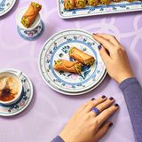 Cannoli  Ein sizilianischer Klassiker mit knuspriger Hülle und cremiger Ricotta-Füllung – ein Stück Italien für Ihre Küche.  Zutaten:250 g Weizenmehl (Type 405) + mehr zum Ausrollen25 g ZuckerSalz25 g Schweineschmalz (zimmerwarm)80 g Marsala oder ein anderer Süßwein2 Eigelb500 g Ricotta25 g Puderzucker25 g dunkle Schokolade1 unbehandelte Orange (Schale)50 g Pistazien (geschält, ungeröstet)14–16 kleine Bambusabschnitte (ca. 12 cm) oder Metallzylinder  Zubereitung:  Für den Teig Mehl, Zucker und eine Prise Salz mit dem Schmalz zu einer krümeligen Masse verarbeiten. Marsala und Eigelb dazugeben und zu einem festen, leicht elastischen Teig kneten. 1 Stunde ruhen lassen.  Für die Füllung den Ricotta in ein Tuch wickeln, ausdrücken und mit Puderzucker glatt rühren. Geraspelte Schokolade und Orangenabrieb untermischen und in einen Spritzbeutel füllen. Die Pistazien hacken.  Den Teig etwa 2 mm dünn ausrollen, mit einem 7,5 cm-Ring ausstechen. Die Scheiben um die Bambusabschnitte oder Zylinder wickeln und die Enden gut andrücken.  Das Fett auf 170 Grad erhitzen und die Cannoli samt Stäben 3–4 Minuten frittieren. Von den Stäben lösen, nochmals 1 Minute frittieren und auf Küchenpapier abtropfen lassen. Nach dem Abkühlen mit Ricotta füllen und die Enden in die Pistazien dippen.  Profi-Tipp: Als Fett am besten Schweineschmalz verwenden.