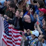Menschen vor US-Flagge jubeln