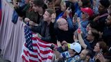 Menschen vor US-Flagge jubeln