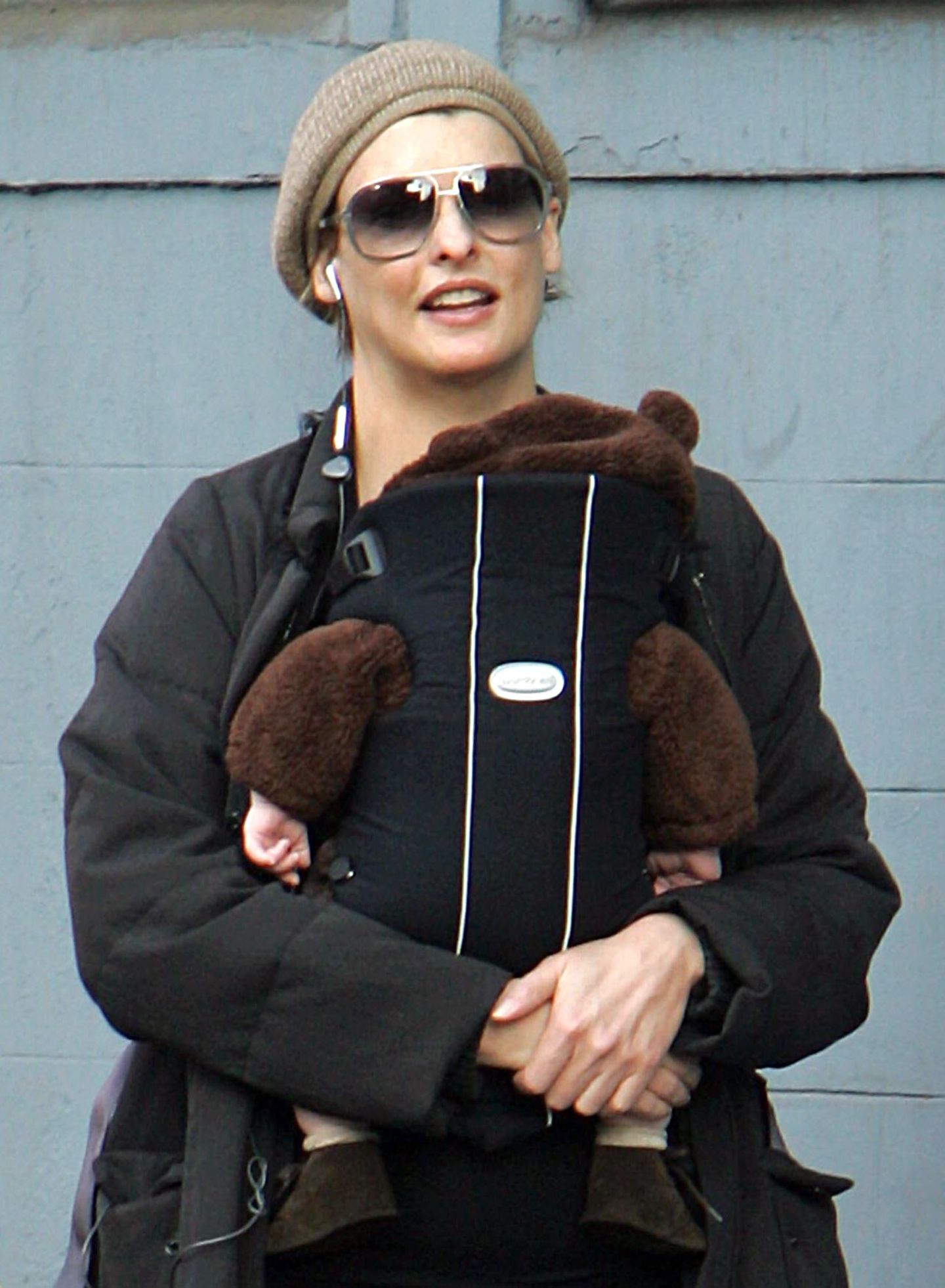 Linda Evangelista mit Sonnenbrille in New York, sie trägt ihr Baby in einer Trage vor der Brust
