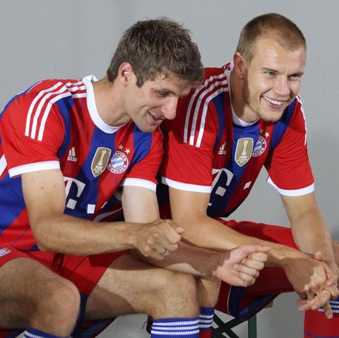 Thomas Müller und Holger Badstuber sitzen 2014 für ein Fotoshooting auf einer Bank