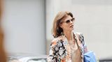 Linda Evangelista hölt ein Geschenk unter dem Arm und ihren sechsjährigen Sohn an der Hand