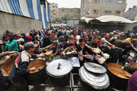 Menschen stehen Schlange für eine warme Mahlzeit im Gazastreifen