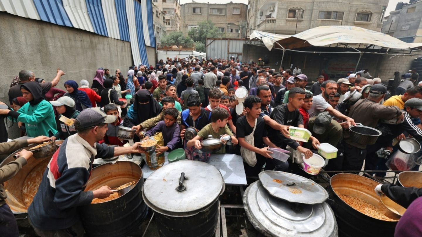 Menschen stehen Schlange für eine warme Mahlzeit im Gazastreifen