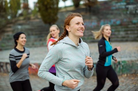 4 Frauen sind draußen am laufen und lachen