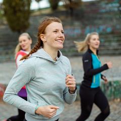 4 Frauen sind draußen am laufen und lachen