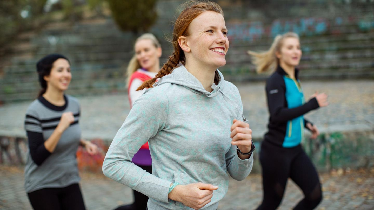 4 Frauen sind draußen am laufen und lachen