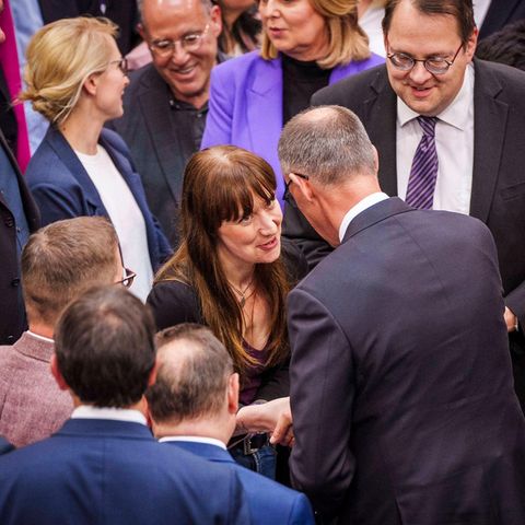 CDU-Chef Friedrich Merz schüttelt im Plenarsaal Linken-Fraktionschefin Heidi Reichinnek die Hand.