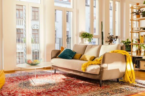 Immobilienkauf Symbolbild: Großzügiges modernes Wohnzimmer in warmen Farben mit Orientteppich